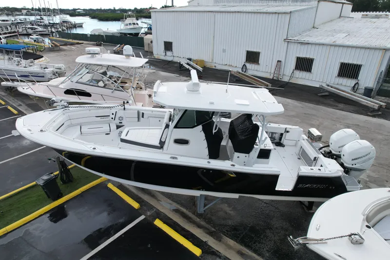  Yacht Photos Pics 2021 Blackfin 332 CC boat docked at a marina, featuring sleek design and twin engines.