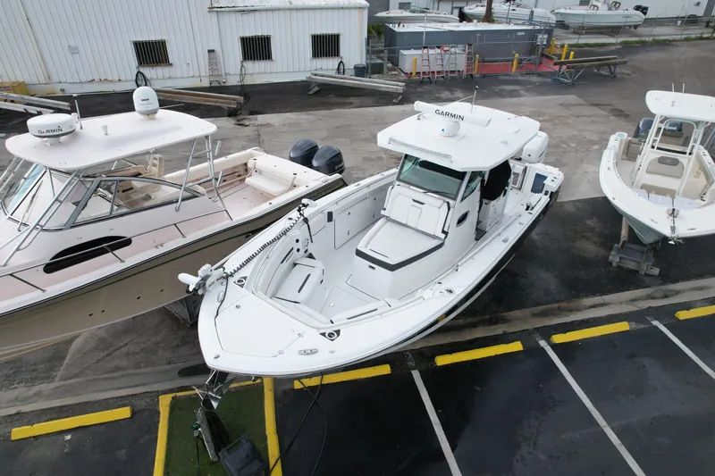  Yacht Photos Pics 2021 Blackfin 332 CC boat docked between two other boats in a marina.
