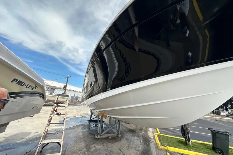  Yacht Photos Pics 2021 Blackfin 332 CC boat on dry dock, with sleek black and white hull.