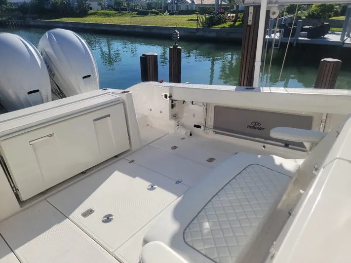  Yacht Photos Pics 2021 Pursuit S 378 Sport boat interior with twin engines, docked by a canal.