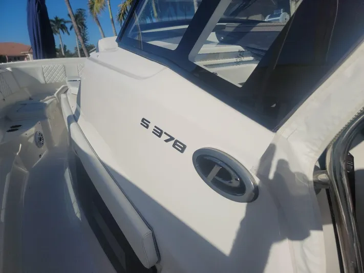  Yacht Photos Pics 2021 Pursuit S 378 Sport boat, sleek white exterior, sunny day, palm trees in background.
