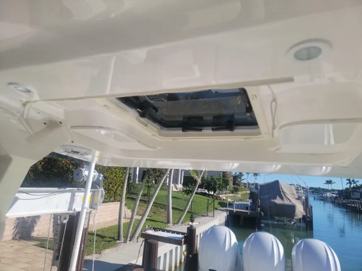 Yacht Photos Pics 2021 Pursuit S 378 Sport boat roof hatch, docked by waterfront homes.