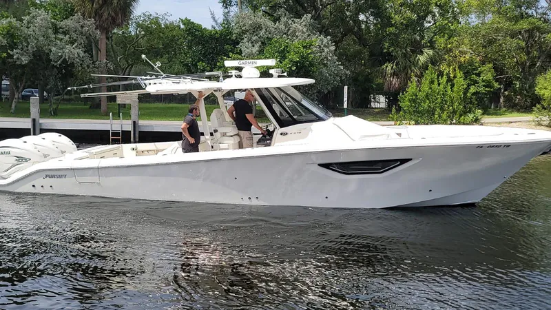  Yacht Photos Pics 2021 Pursuit S 378 Sport boat on calm water with lush greenery background.