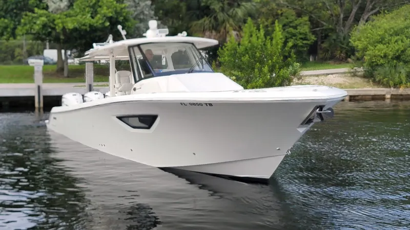  Yacht Photos Pics 2021 Pursuit S 378 Sport boat on calm water near a dock.