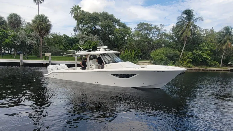  Yacht Photos Pics 2021 Pursuit S 378 Sport boat cruising on a calm river with lush greenery.