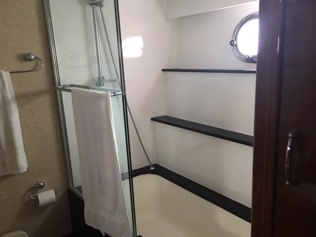 Silver Lining Yacht Photos Pics Bathroom in 2005 Marquis Fly Bridge yacht with shower, towel rack, and porthole window.