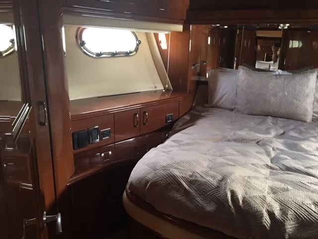 Silver Lining Yacht Photos Pics Luxurious bedroom in 2005 Marquis Fly Bridge yacht with wood cabinetry and porthole window.