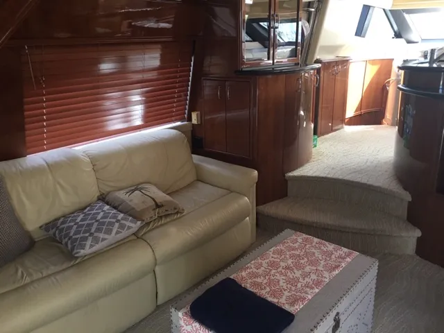 Silver Lining Yacht Photos Pics Interior of 2005 Marquis Fly Bridge yacht with beige sofa and wooden cabinetry.