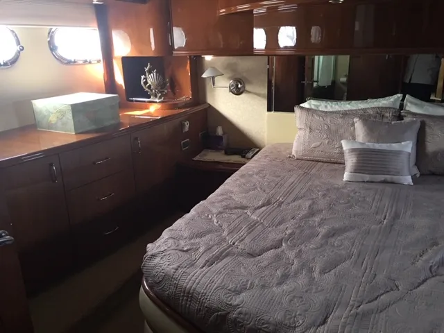 Silver Lining Yacht Photos Pics Luxurious bedroom interior of a 2005 Marquis Fly Bridge yacht with elegant wood finishes.