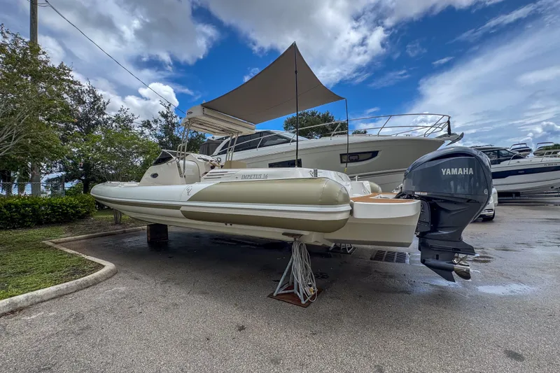  Yacht Photos Pics 2023 Tender Impertus 36 boat with Yamaha engine, parked outdoors under a cloudy sky.
