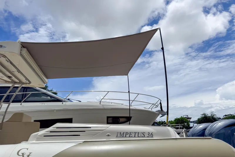  Yacht Photos Pics 2023 Tender Impertus 36 boat with canopy under a partly cloudy sky.