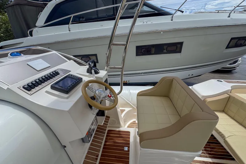  Yacht Photos Pics 2023 Tender Impertus 36 boat interior with steering console and seating area.