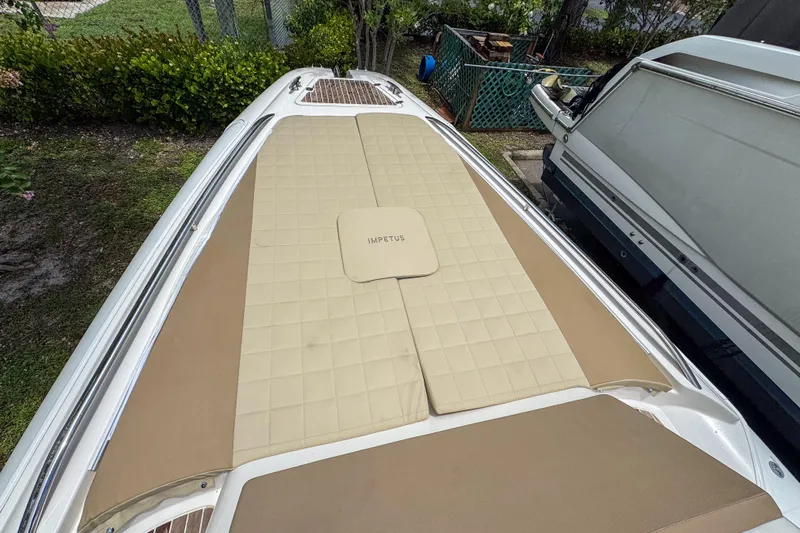  Yacht Photos Pics 2023 Tender Impertus 36 boat with beige cushioned deck, parked outdoors.