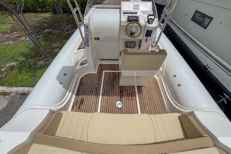  Yacht Photos Pics 2023 Tender Impertus 36 boat interior with beige seating and wooden flooring.