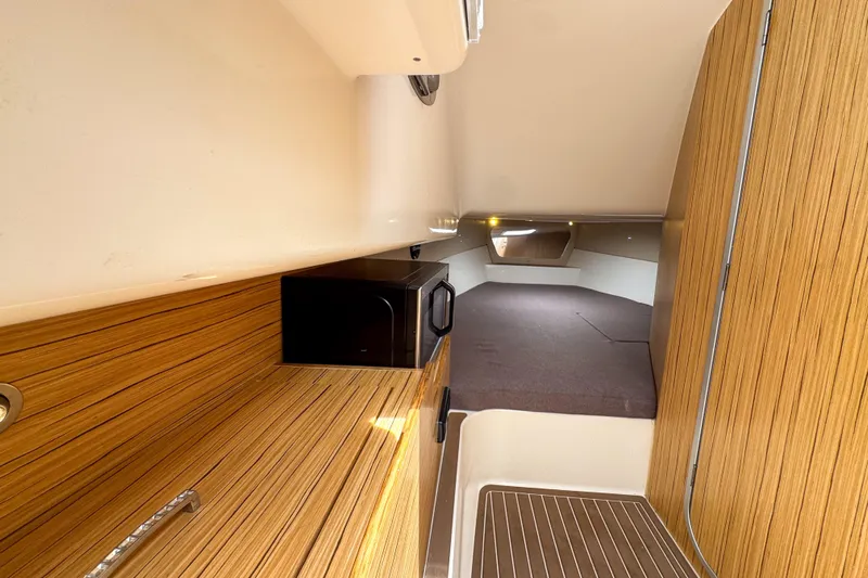  Yacht Photos Pics Interior of 2023 Tender Impertus 36 boat with wood finish and compact kitchen area.