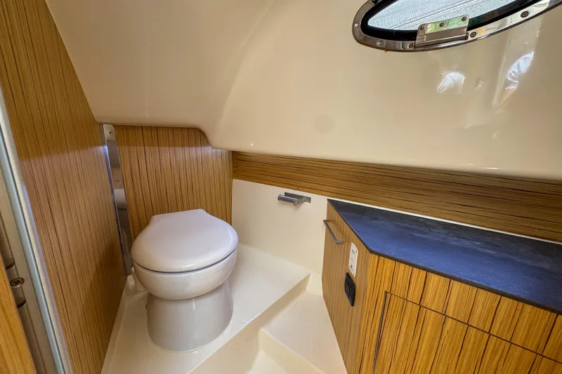  Yacht Photos Pics Modern bathroom interior of 2023 Tender Impertus 36 boat with wood accents and porthole.
