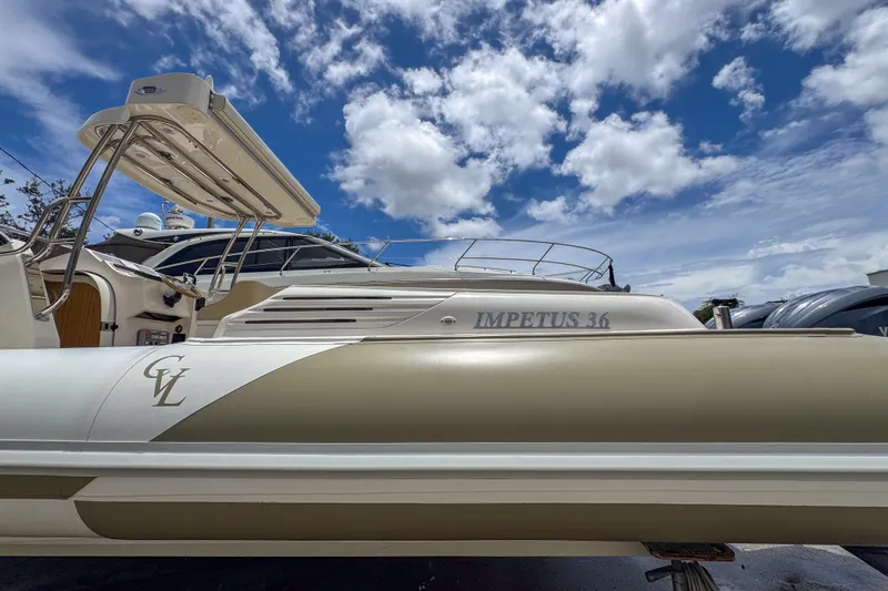  Yacht Photos Pics 2023 Tender Impertus 36 boat under a vibrant blue sky with clouds.
