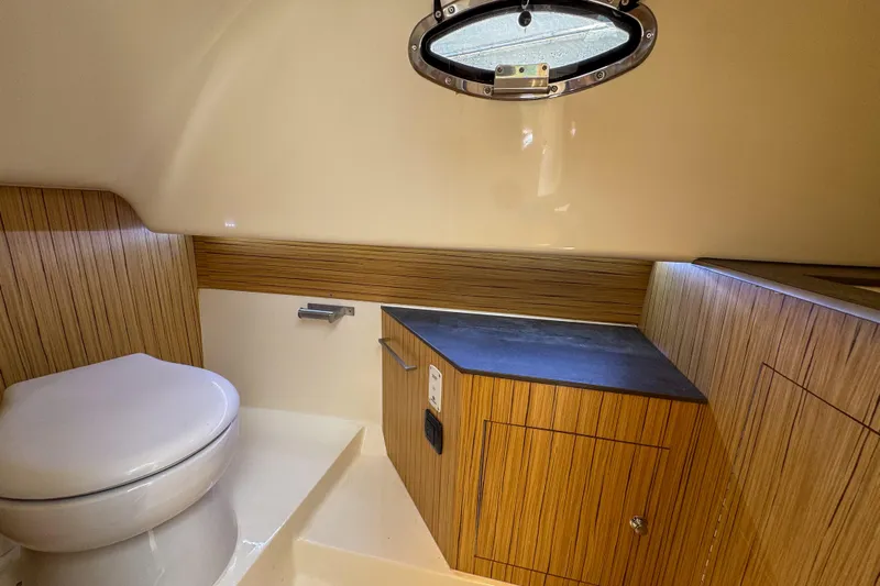  Yacht Photos Pics Modern bathroom interior of 2023 Tender Impertus 36 yacht with wood accents and porthole.