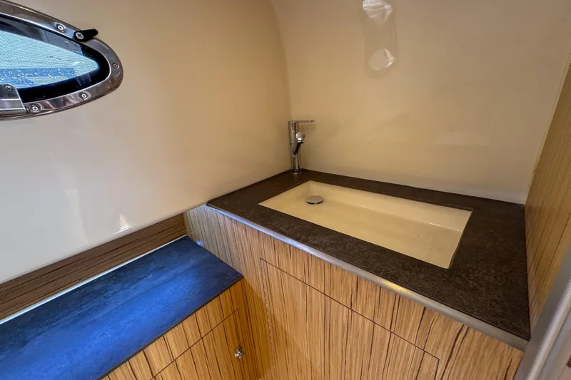  Yacht Photos Pics Modern bathroom interior of 2023 Tender Impertus 36 yacht with sleek sink and wooden cabinetry.
