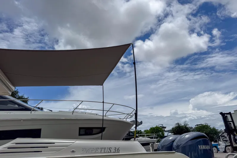  Yacht Photos Pics 2023 Tender Impertus 36 boat with canopy under a partly cloudy sky.