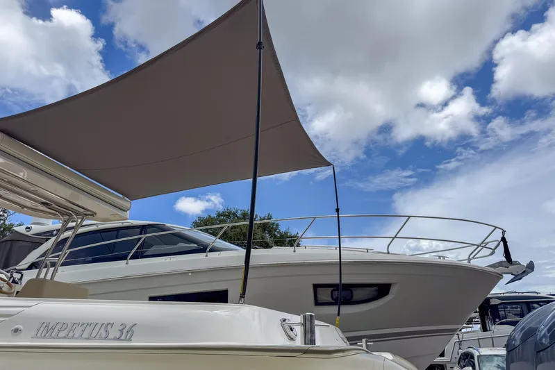  Yacht Photos Pics 2023 Tender Impertus 36 yacht under a sunshade, with a cloudy sky backdrop.