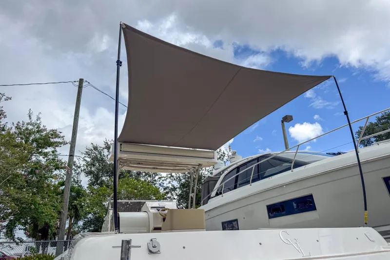  Yacht Photos Pics 2023 Tender Impertus 36 yacht with sunshade, docked under cloudy sky.