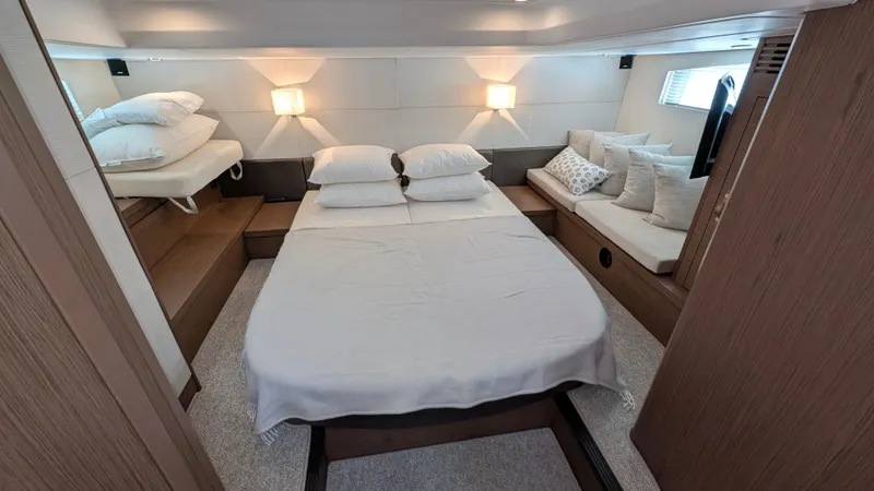 Best Life Yacht Photos Pics Luxurious bedroom interior of 2019 Beneteau GT 46 yacht with cozy bedding and ambient lighting.