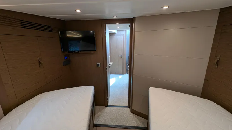 Best Life Yacht Photos Pics 2019 Beneteau GT 46 cabin interior with twin beds and wall-mounted TV.