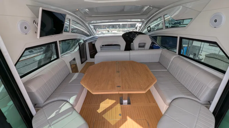 Best Life Yacht Photos Pics Interior of 2019 Beneteau GT 46 yacht with spacious seating and wooden table.