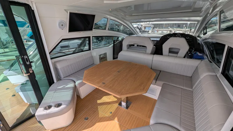 Best Life Yacht Photos Pics Interior of 2019 Beneteau GT 46 yacht with spacious seating and wooden table.