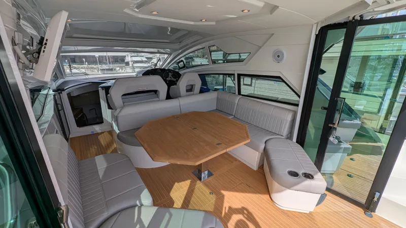 Best Life Yacht Photos Pics Interior of 2019 Beneteau GT 46 yacht with spacious seating and wooden table.
