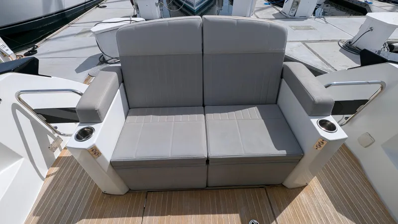 Best Life Yacht Photos Pics Gray seating on 2019 Beneteau GT 46 yacht deck, featuring cup holders and armrests.