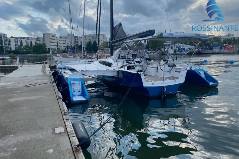  Yacht Photos Pics 2021 Dragonfly 40 trimaran docked at marina, overcast sky, calm water reflections.