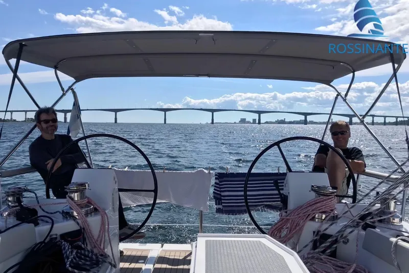  Yacht Photos Pics Two people relaxing on a Dragonfly 40 sailboat, 2021 model, with a scenic bridge view.