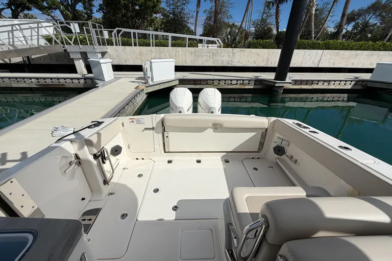  Yacht Photos Pics 2022 Boston Whaler 320 Vantage boat interior at dock, featuring spacious seating and dual engines.