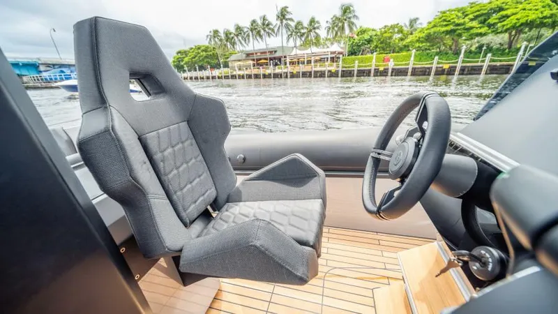  Yacht Photos Pics Captain's seat and steering wheel of 2025 Skipper 38 NC boat, with water and trees in background.