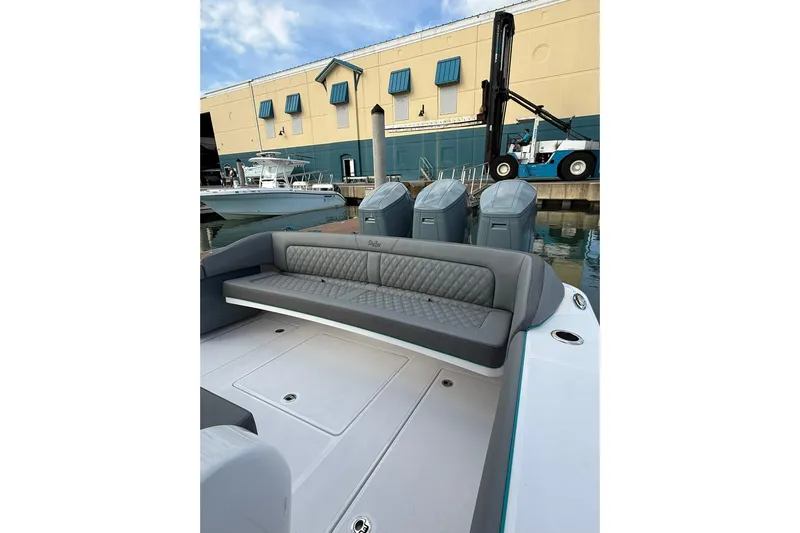  Yacht Photos Pics 2026 Mag Bay 43 CC boat with gray seating, docked near a warehouse.