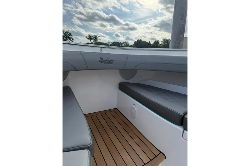  Yacht Photos Pics Interior view of 2026 Mag Bay 43 CC boat with cushioned seating and wooden flooring.