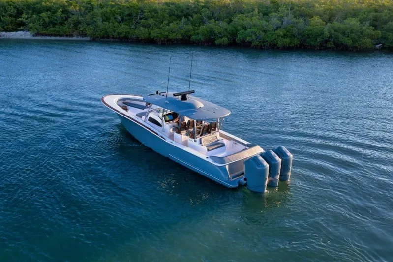  Yacht Photos Pics 2026 Mag Bay 43 CC boat cruising on calm water near lush shoreline.