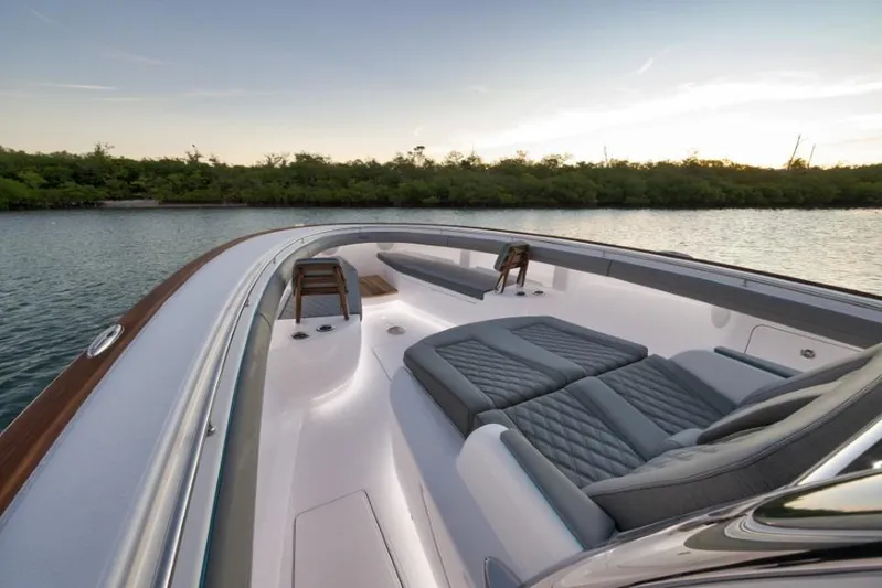  Yacht Photos Pics 2026 Mag Bay 43 CC luxury boat interior with cushioned seating, on calm water at sunset.