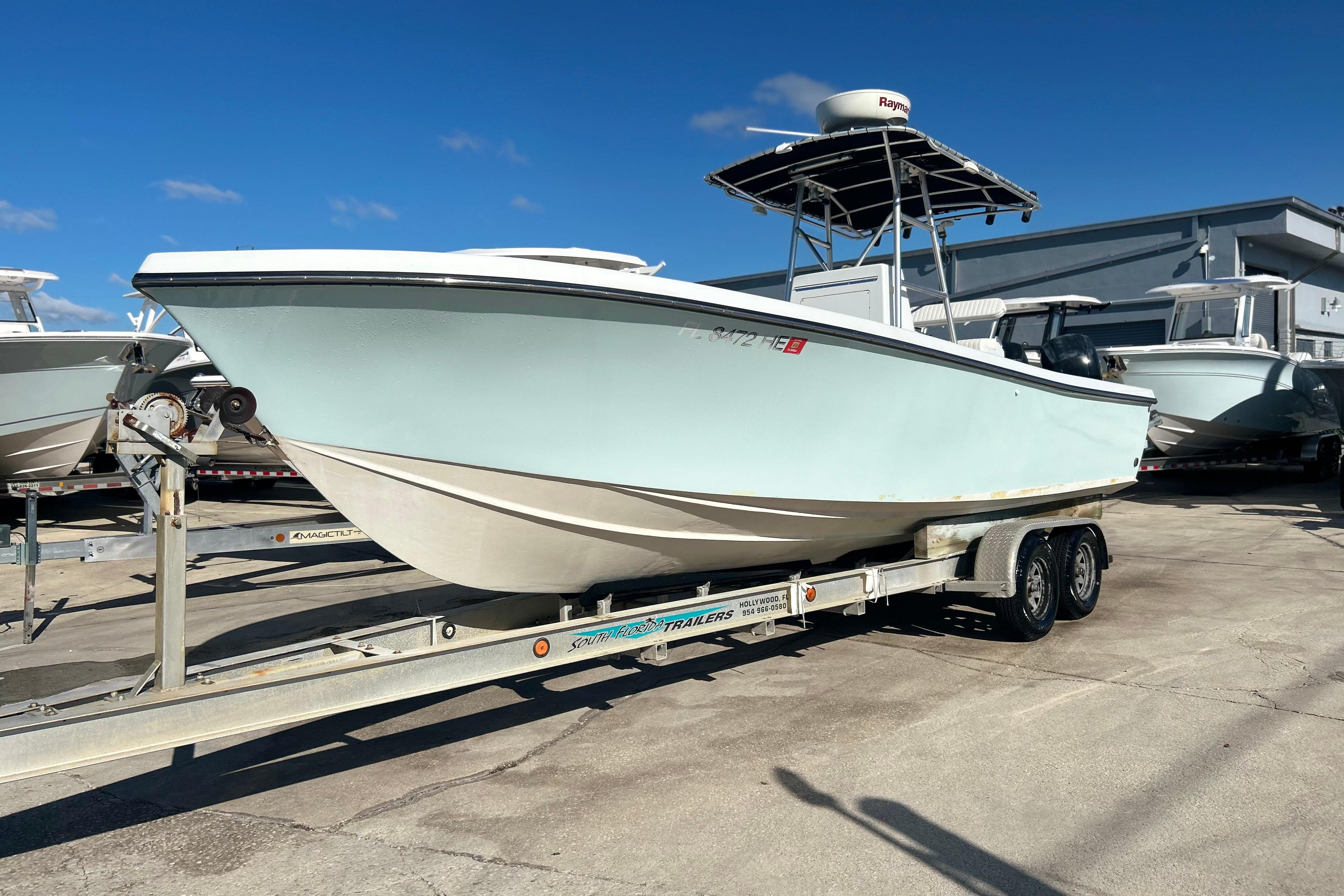 1991 Contender 25 Open boat on trailer, parked outdoors under clear blue sky.
