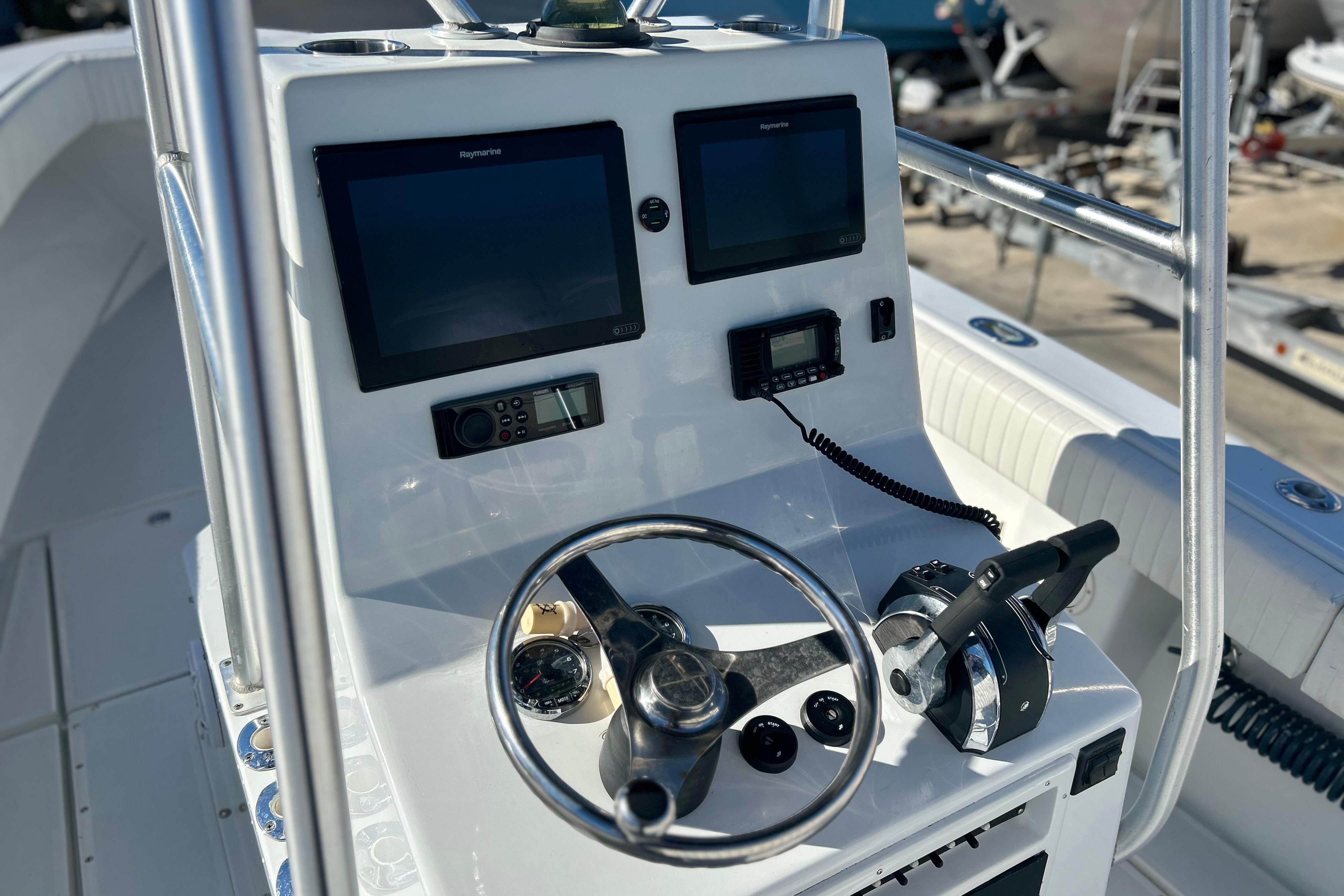 1991 Contender 25 Open boat console with steering wheel, dual screens, and control panel.