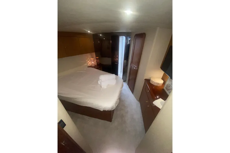  Yacht Photos Pics Luxurious bedroom interior of 2002 Ocean Yacht Super Sport, featuring cozy bed and elegant decor.