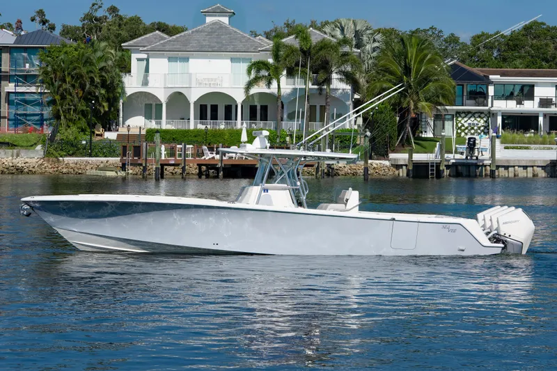 Yacht Photos Pics 2024 SeaVee 390B boat on water, luxury waterfront homes in background.