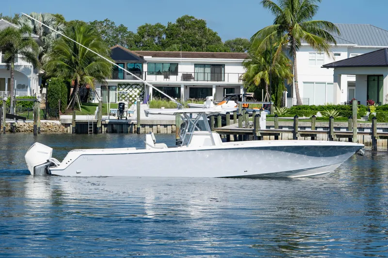  Yacht Photos Pics 2024 SeaVee 390B boat docked near waterfront homes, surrounded by palm trees.