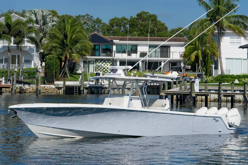  Yacht Photos Pics 2024 SeaVee 390B boat docked near waterfront homes with palm trees.