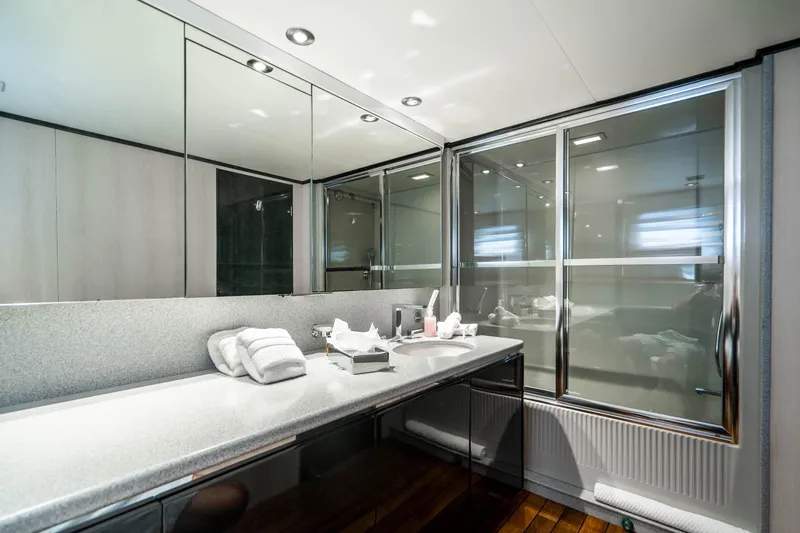 Quantum Yacht Photos Pics Luxurious bathroom on a 1989 Broward Tri-Deck yacht with modern fixtures and large mirrors.