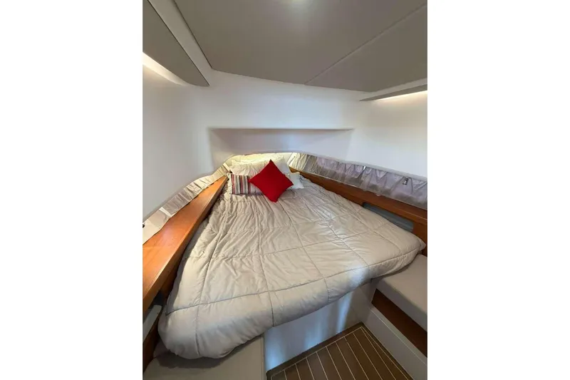 Dirty Money Yacht Photos Pics Cozy cabin interior of 2021 Nimbus T-11 with bed and red accent pillow.