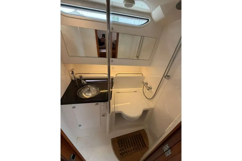 Dirty Money Yacht Photos Pics Compact bathroom in 2021 Nimbus T-11 boat with sink, shower, and mirror.