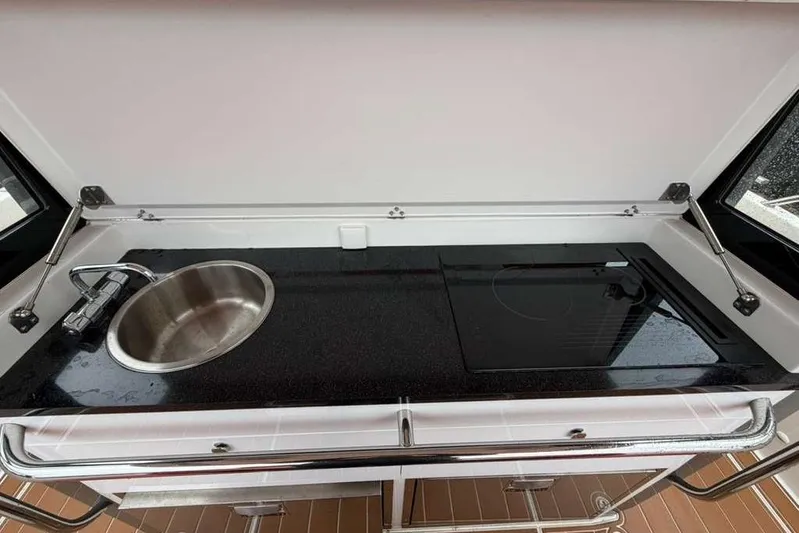 Dirty Money Yacht Photos Pics Compact kitchen in 2021 Nimbus T-11 with sink and induction cooktop.